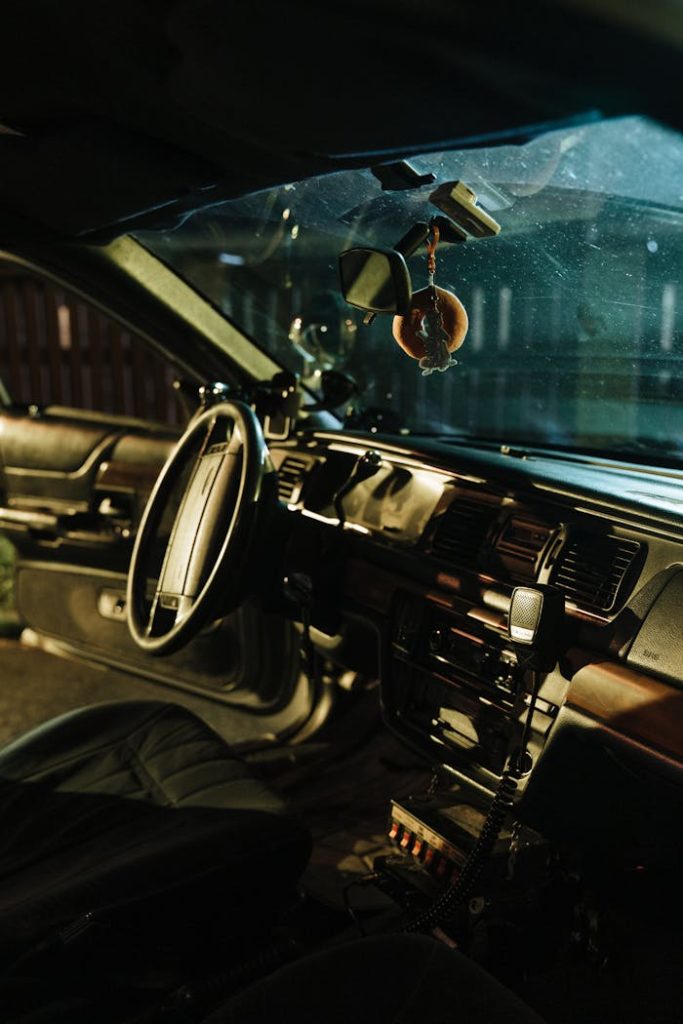 Moody night shot of a car interior showcasing steering wheel and dashboard lighting.